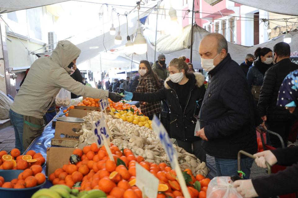 People put masks on their faces and shop their needs from the popular market on April 8 in Istanbul.