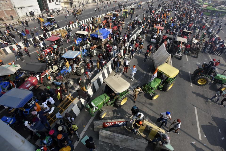 NEW DELHI, INDIA - JANUARY 26: Demonstrators in large numbers at NH-24 during the farmers' tractor rally on Republic Day, on January 26, 2021 in New Delhi, India. Major scenes of chaos and mayhem at Delhi borders as groups of farmers allegedly broke barricades and police check posts and entered the national capital before permitted timings. Police used tear gas at Delhi's Mukarba Chowk to bring the groups under control. Clashes were also reported at ITO, Akshardham. Several rounds of talks between the government and protesting farmers have failed to resolve the impasse over the three farm laws. The kisan bodies, which have been protesting in the national capital for almost two months, demanding the repeal of three contentious farm laws have remained firm on their decision to hold a tractor rally on the occasion of Republic Day.(Photo by Sanjeev Verma/Hindustan Times via Getty Images)