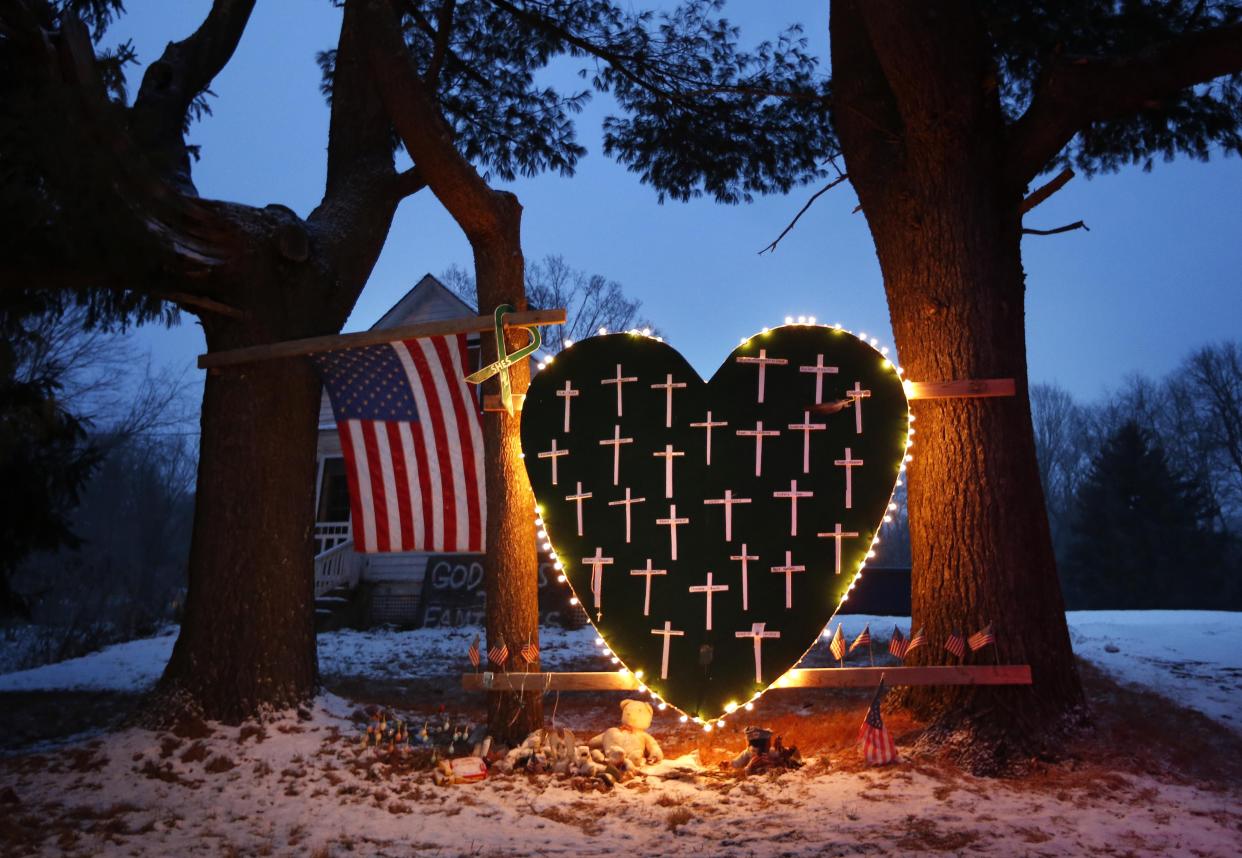 In this Dec. 14, 2013, file photo, a makeshift memorial with crosses for the victims of the Sandy Hook massacre stands outside a home in Newtown, Conn., the one-year anniversary of the shootings. 