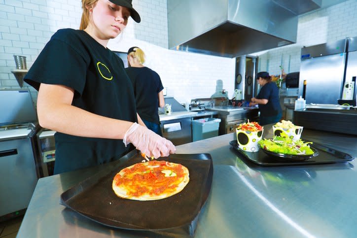 Una persona trabaja en la cocina de un restaurante de comida rápida