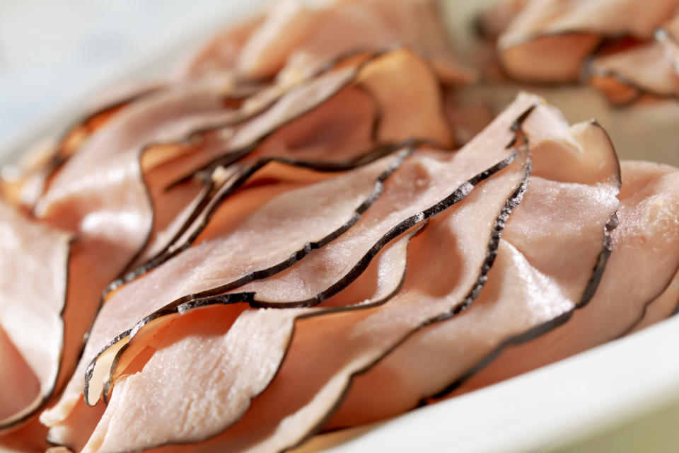 Close up image of sliced black forest ham on a white tray