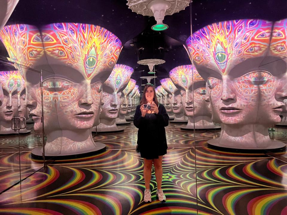 The author in the mirror surrounded by digital art heads.