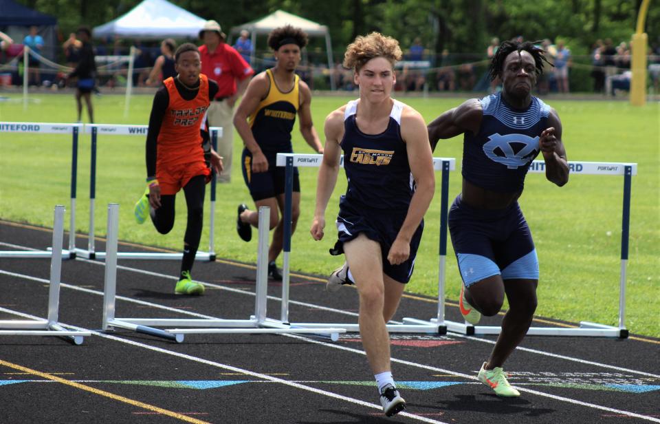 Erie Mason's Louden Murbach (left) sprints to the finish line in first place ahead of Deshaun Williams of Detroit Voyageur in the 110-meter hurdles during the Division 3 Regional Saturday, May 21, 2022 at Whiteford. Behind are Devonte Hughes of Taylor Prep and Seamus Waterford of Whiteford.