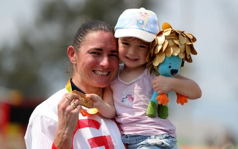 Sarah Storey celebrates winning gold in the road race at the Rio Paralympics with daughter Louisa - Credit: PA