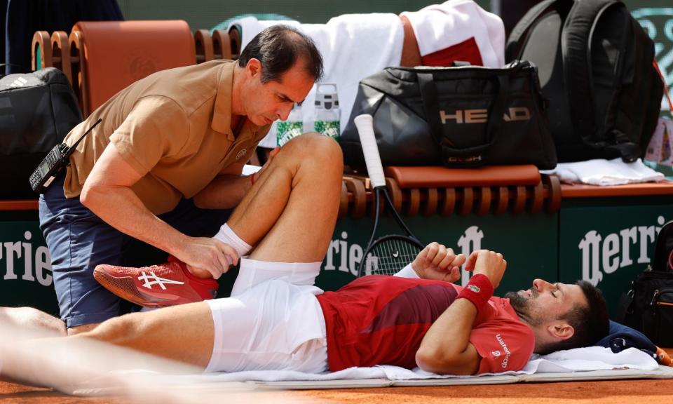 <span>Novak Djokovic receives medical assistance for his right knee during his fourth round match at the French Open.</span><span>Photograph: Jean-François Badias/AP</span>