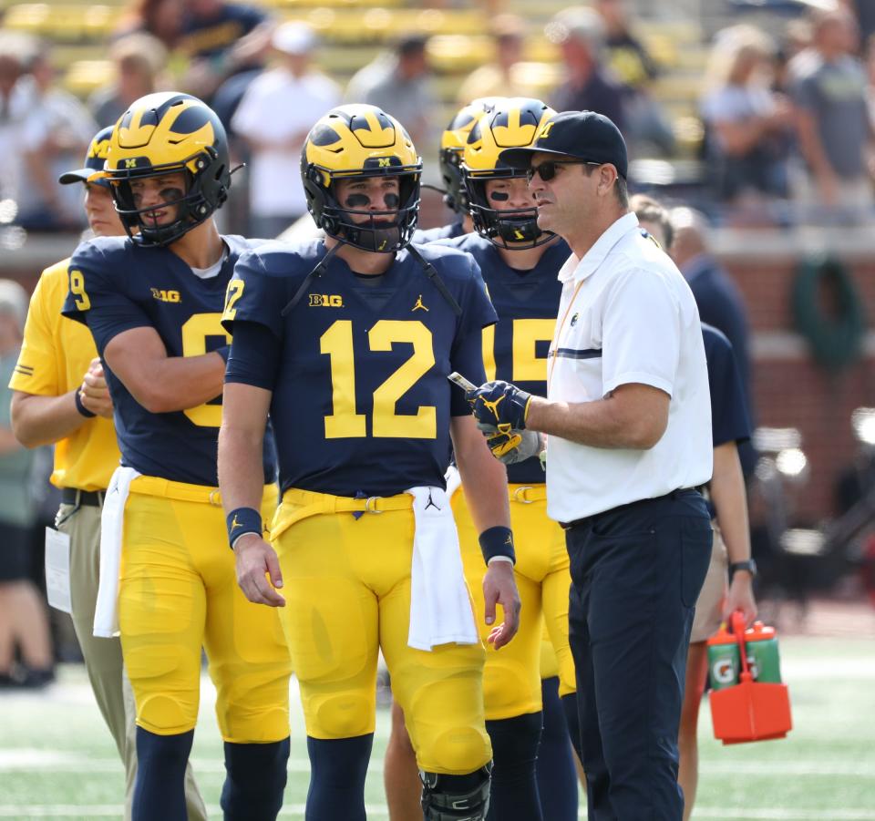 Michigan coach Jim Harbaugh and quarterback Cade McNamara on the field before the game against Western Michigan on Saturday, Sept. 4, 2021, in Ann Arbor.