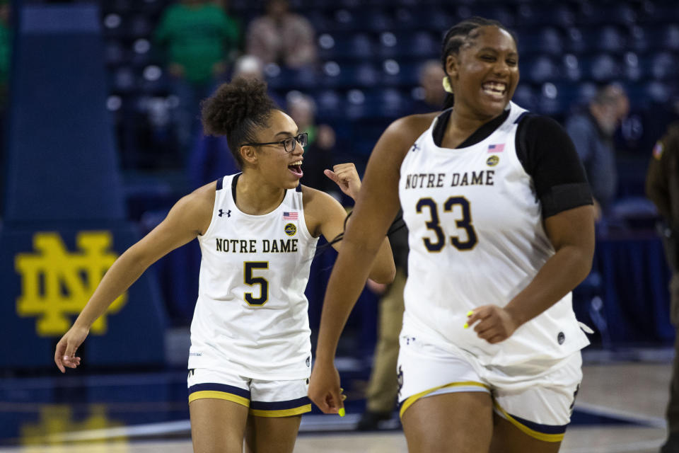 Notre Dame's Olivia Miles (5) and Lauren Ebo (33) smile as they walk off the court after an NCAA college basketball game against Merrimack on Saturday, Dec. 10, 2022 in South Bend, Ind. (AP Photo/Michael Caterina)