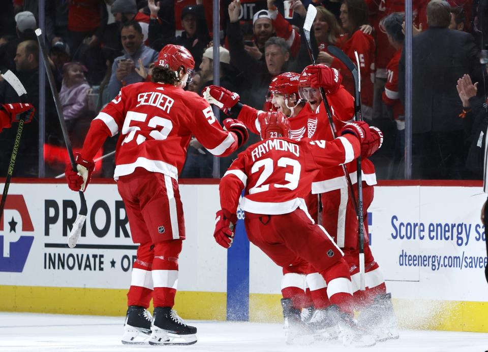 Detroit Red Wings right wing Patrick Kane, second from right, celebrates with teammates Moritz Seider (53), Lucas Raymond (23) and Andrew Copp after scoring in overtime against the Columbus Blue Jackets in an NHL hockey game Tuesday, March 19, 2024, in Detroit. (AP Photo/Duane Burleson)