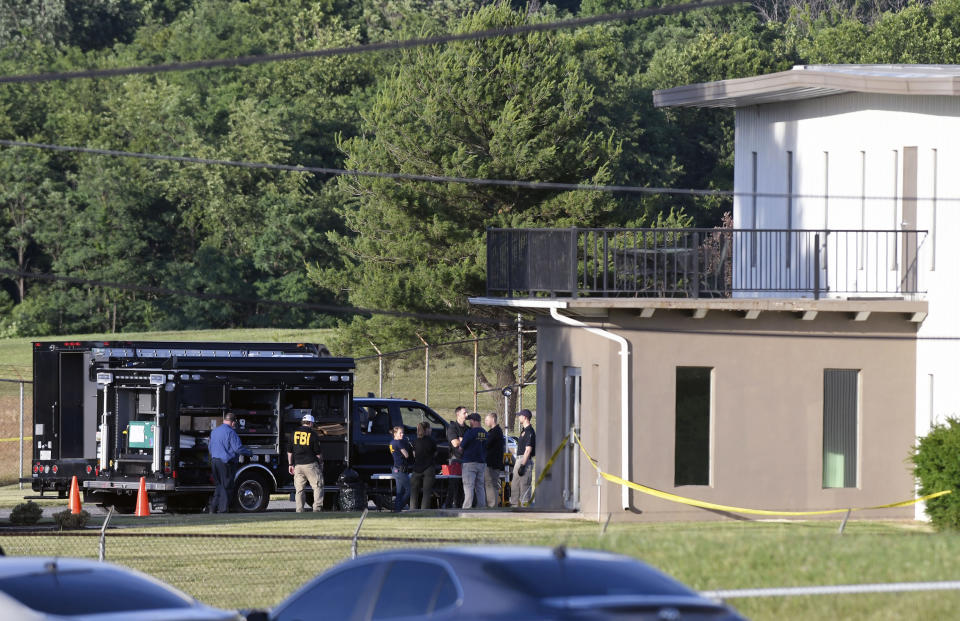 Law enforcement works near where a man opened fire at a business, killing three people before the suspect and a state trooper were wounded in a shootout, according to authorities, in Smithsburg, Md., Thursday, June 9, 2022. The Washington County (Md.) Sheriff's Office said in a news release that three victims were found dead at Columbia Machine Inc. and a fourth victim was critically injured. (AP Photo/Steve Ruark)