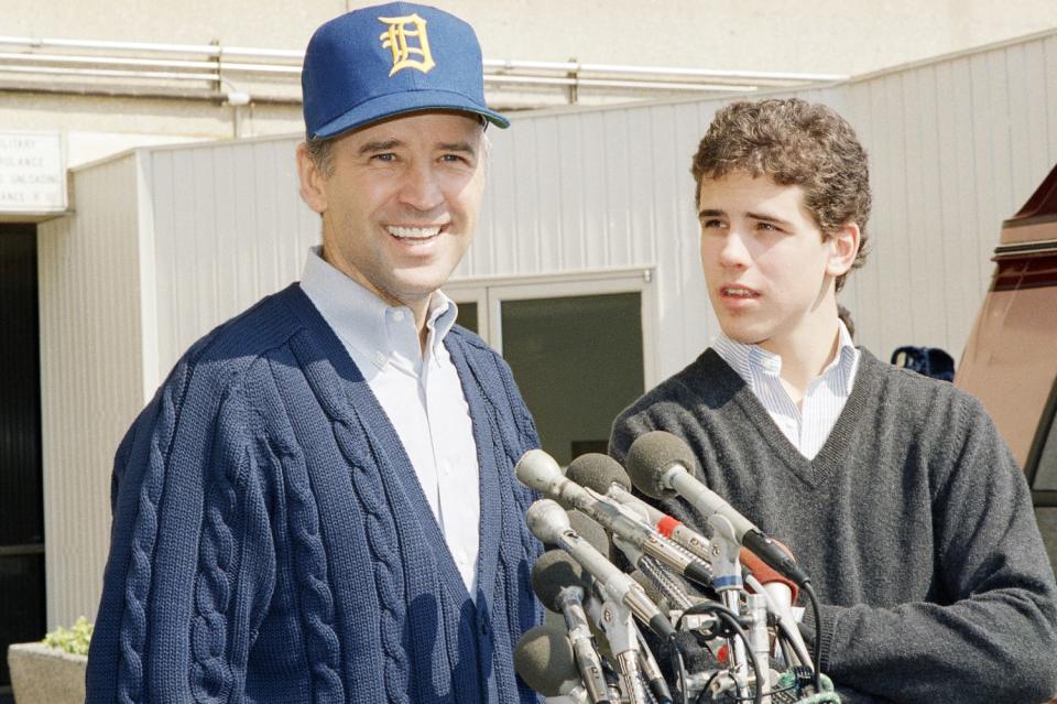 Sen. Joseph Biden (D-Del.), wearing a University of Delaware baseball cap, leaves Walter Reed Hospital with son Hunter.