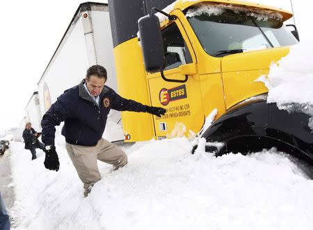 New York Governor Andrew Cuomo climbs over snow piled on the highway after talking with a stranded trucker on interstate I-190 while surveying an area in West Seneca, New York November 19, 2014. REUTERS/Sharon Cantillon/Buffalo News/Pool