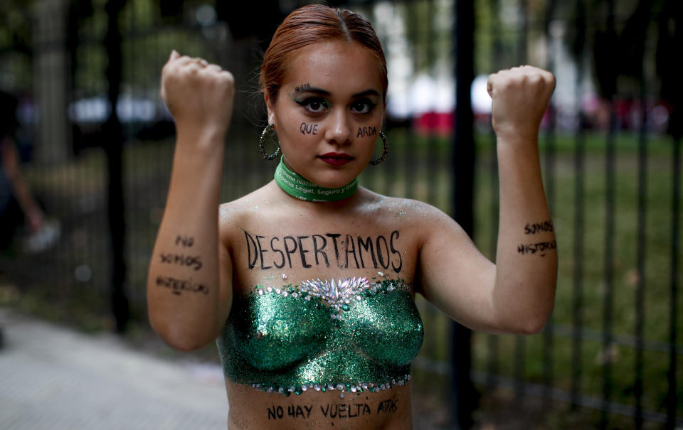 A woman poses for a photo with the words "We woke up" written in Spanish on her chest during a march to commemorate International Women's Day in Buenos Aires, Argentina, Monday, March 9, 2020. (AP Photo/Natacha Pisarenko)