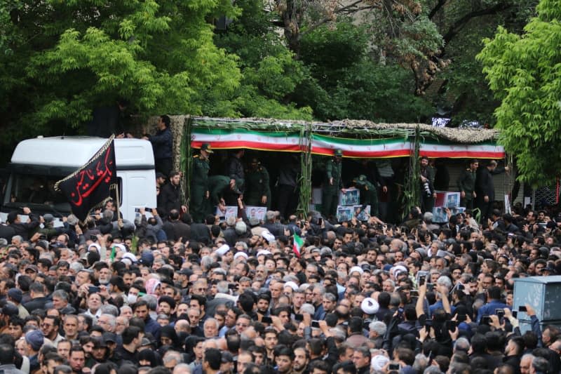 People participate in a funeral procession of Iran's late President Ebrahim Raisi and his seven aides who were killed in a helicopter crash on a fog-shrouded mountainside in the northwest. Mehrvarz Ahmadi/dpa