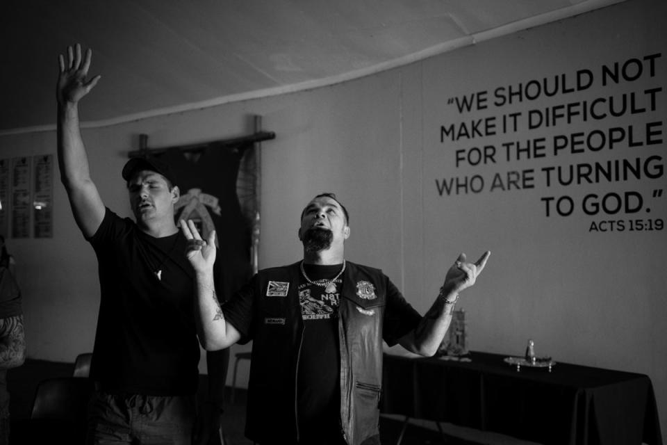 A CMA member and his friend pray during a weekly church service in Midrand, Johannesburg (EPA)