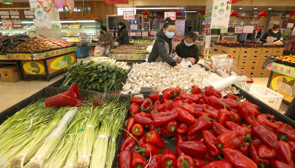 Pictured are Chinese customers in a supermarket vegetable section.