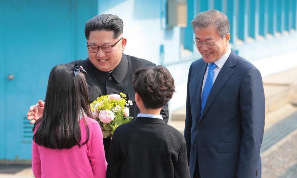 North Korean leader Kim Jong-un and South Korean President Moon Jae-in with children presenting flowers to Kim.