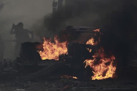 Residents extinguish a fire caused by what activists say was an air strike by forces loyal to Syria's President Bashar al-Assad on Tal Abyad street market in central Raqqa September 6, 2014. REUTERS/Stringer