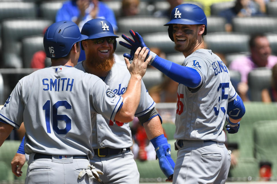 Los Angeles Dodgers' Cody Bellinger, right, celebrates his three-run home run with Will Smith (16) and Justin Turner during the first inning of a baseball game against the Atlanta Braves, Sunday, Aug. 18, 2019, in Atlanta. (AP Photo/John Amis)