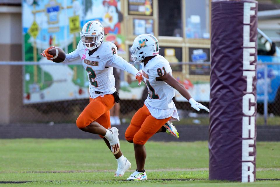 Mandarin's Jaime Ffrench celebrates with teammate Josiah Watkins (81) after Ffrench took a pass for a 65 yard touchdown in early first quarter action. The Fletcher Senators football team hosted the Mandarin Mustangs Friday evening, August 26, 2022 at the Senators Neptune Beach stadium.