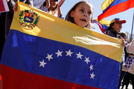 A girl displays the Venezuelan flag as opponents of Venezuelan President Nicolas Maduro rally outside the White House in Washington, U.S., March 16, 2019. REUTERS/Joshua Roberts