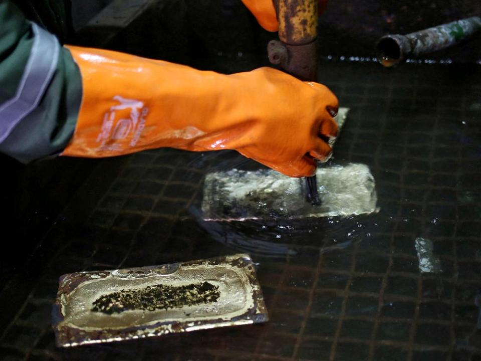 FILE PHOTO: A worker cleans gold bars at South Africa's Gold Fields South Deep mine in Westonaria