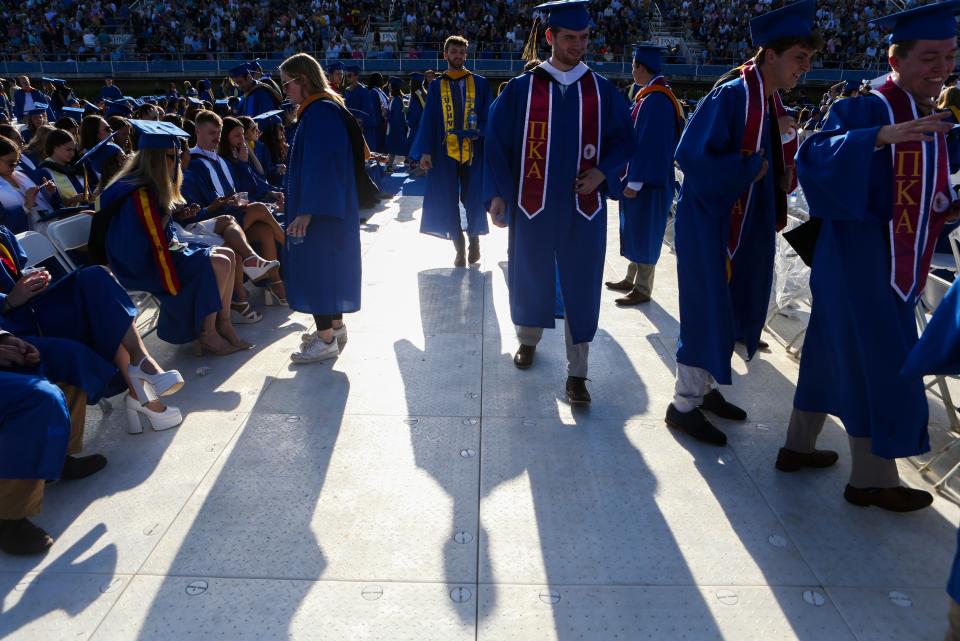 Graduates mingle under a strong sun during the hours-long wait for the start of the University of Delaware's 2022 Commencement at Delaware Stadium, Saturday, May 28, 2022.