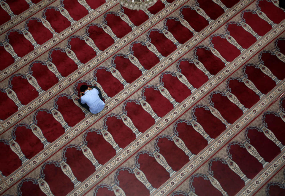 A Muslim man sits inside a mosque