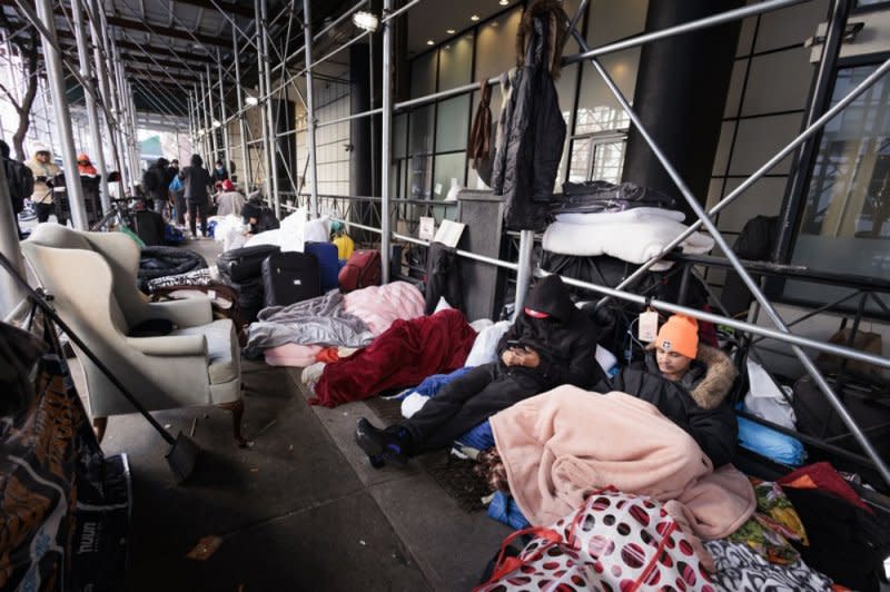 Some of the many migrants who have been bused to New York from the southern U.S. border are shown sitting among their belongings and sleeping bags outside of a New York City hotel in February 2023. File Photo by Justin Lane/EPA-EFE