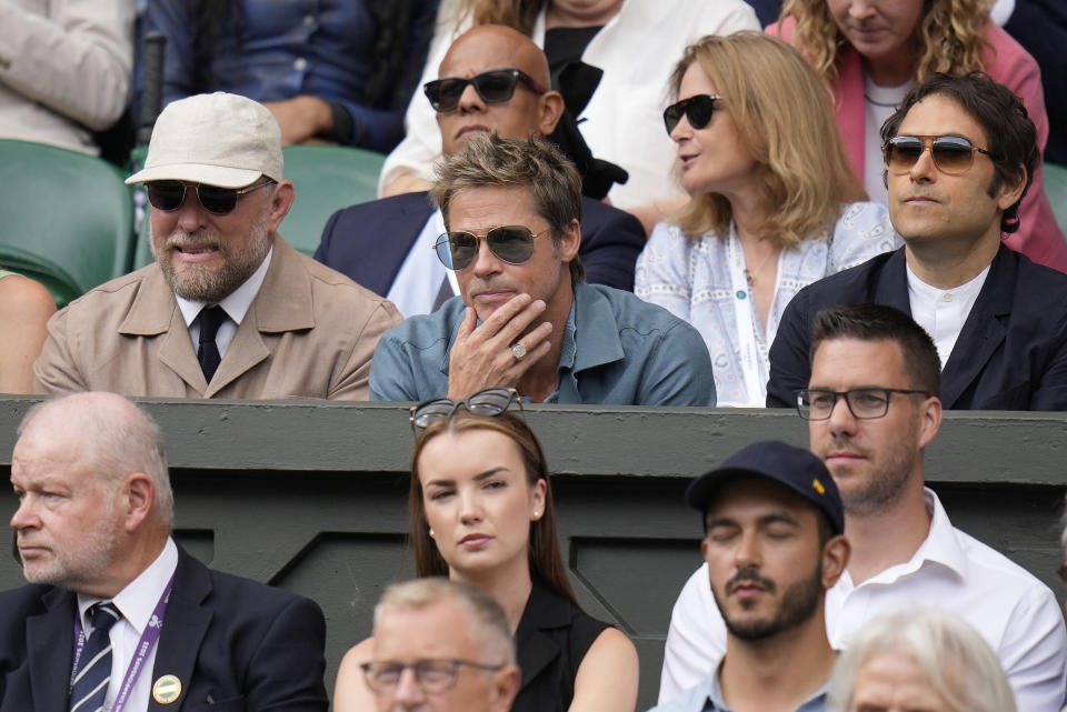 El actor Brad Pitt, al centro, sentado en las gradas de la cancha central para la final de individuales masculinos entre el español Carlos Alcaraz y el serbio Novak Djokovic en el día catorce del campeonato de tenis de Wimbledon en Londres, el domingo 16 de julio de 2023. (Foto AP/ Kirsty Wigglesworth)