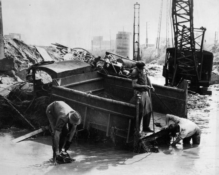 March 2, 1938: Salvage crew trys to dig out gravel truck damaged by flooding along the Los Angeles River. Truck was at construction project to build railroad crossing for Union Pacific across the river. This photo was published in the March 3, 1938 Los Angeles.