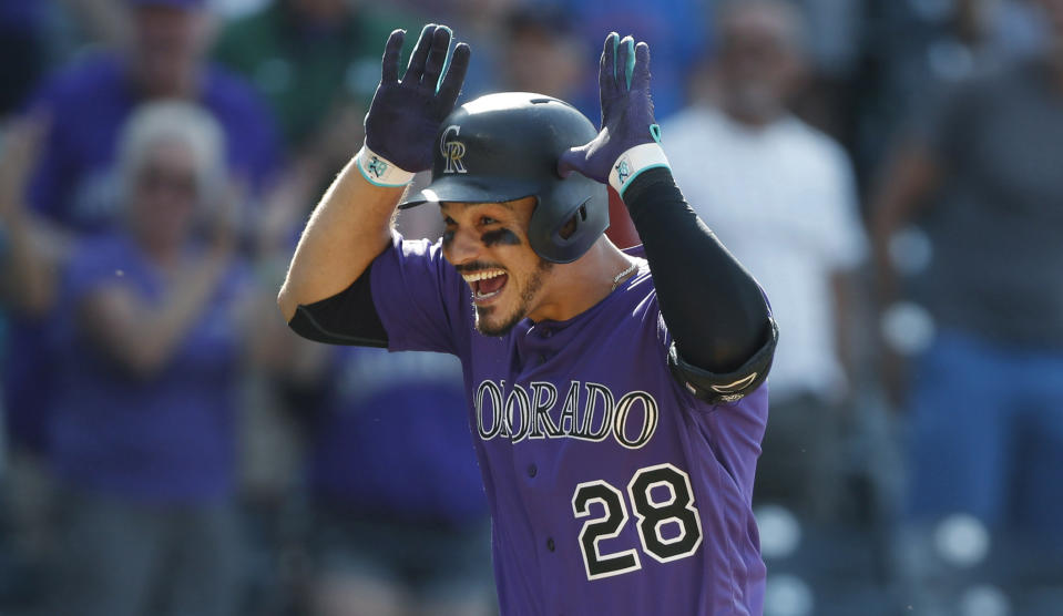 FILE In this Aug. 14, 2019, file photo, Colorado Rockies' Nolan Arenado celebrates as he circles the bases after hitting a walkoff, two-run home run off Arizona Diamondbacks relief pitcher Archie Bradley in the ninth inning of a baseball game in Denver. Arenado is at odds with the team's front office as the Rockies head to spring training for the season ahead. (AP Photo/David Zalubowski, File)