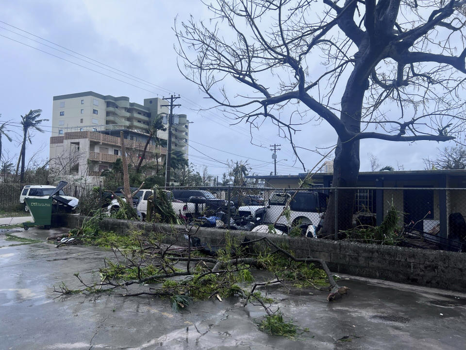 In this photo provided by Scottie Catherine McCorsley, downed tree branches litter a neighbor in Tamuning, Guam, Thursday, May 25, 2023, after Typhoon Mawar passed over the island. Guam residents and officials emerged from homes and shelters Thursday to survey the damage done to the U.S. Pacific territory after a long night of hunkering down as Typhoon Mawar's howling winds shredded trees, flipped vehicles and knocked out utilities. (Scottie Catherine McCorsley via AP)