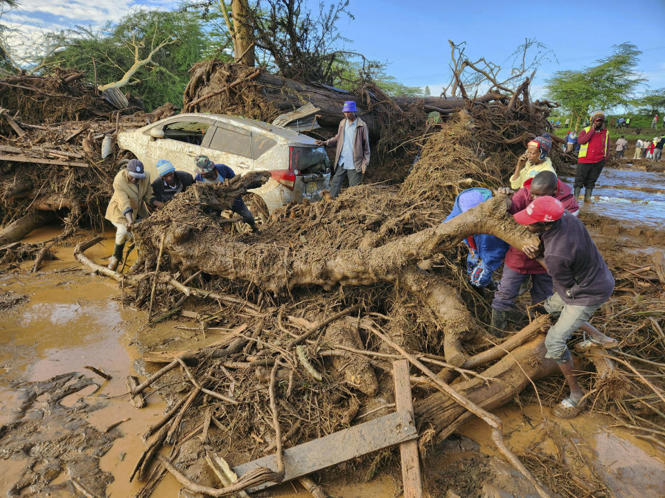 CORRECTS REFERENCE FROM BURST DAM TO BLOCKED TUNNEL - People try to clear the area after a river broke through a blocked tunnel causing floodwaters in the Mai Mahiu area of Nakuru County, Kenya, Monday, April 29, 2024. (AP Photo)