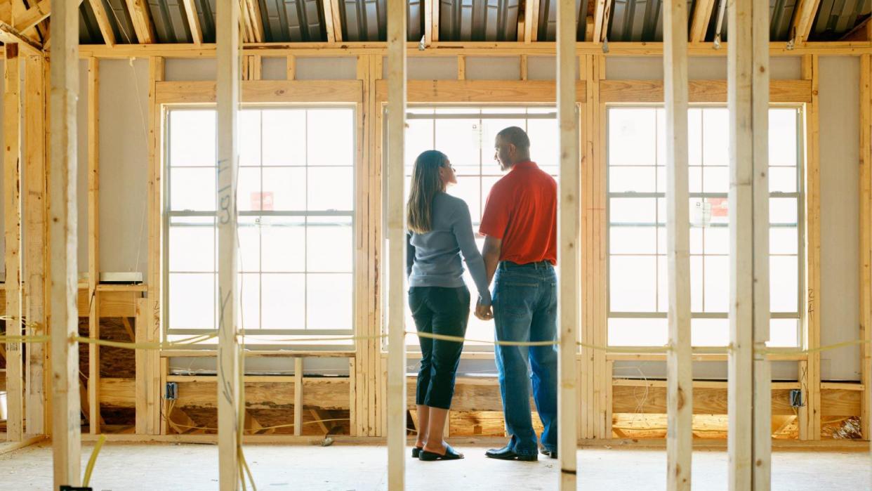 Couple holding hands in home under construction