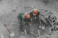 Soldiers search for victims in a location where a house is buried beneath volcanic ash from the eruption of Mount Semeru in Candi Pure village, Lumajang, East Java, Indonesia, Tuesday, Dec. 7, 2021. Indonesia's president on Tuesday visited areas devastated by the powerful volcanic eruption that killed a number of people and left thousands homeless, and vowed that communities would be quickly rebuilt. (AP Photo/Trisnadi)