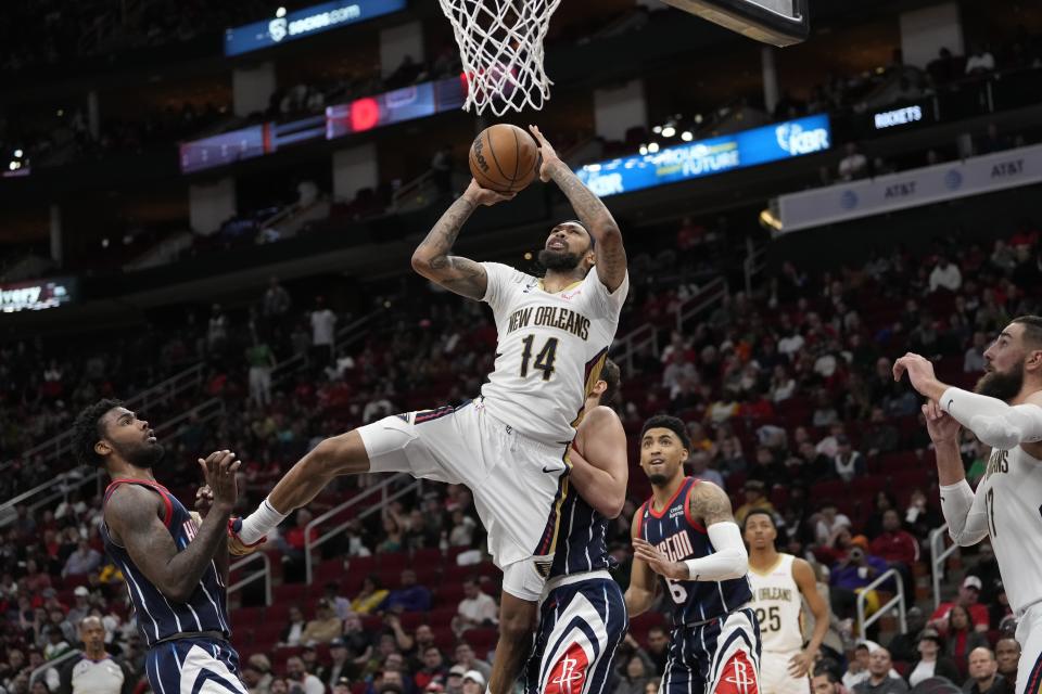 New Orleans Pelicans' Brandon Ingram (14) shoots as Houston Rockets' Tari Eason, left, and Alperen Sengun defend during the second half of an NBA basketball game Friday, March 17, 2023, in Houston. The Rockets won 114-112. (AP Photo/David J. Phillip)