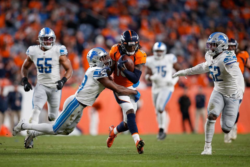 Denver Broncos wide receiver Jerry Jeudy (10) is tackled by Detroit Lions safety C.J. Moore (38) as linebacker Jessie Lemonier (52) defends in the fourth quarter at Empower Field at Mile High on Dec. 12, 2021.