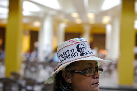 A woman wearing a hat participates in a vigil to await the announcement of the canonization date for slain Salvadorean Archbishop Oscar Arnulfo Romero in San Salvador, El Salvador on May 19, 2018. The words on her hat read "Saint Romero". REUTERS/Jose Cabezas