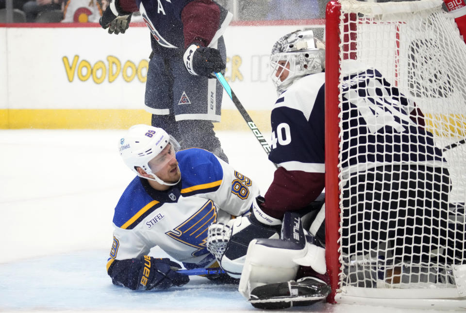 St. Louis Blues left wing Pavel Buchnevich, left, slides against Colorado Avalanche goaltender Alexandar Georgiev while scoring a shorthanded goal during the second period of an NHL hockey game Saturday, Nov. 11, 2023, in Denver. (AP Photo/David Zalubowski)