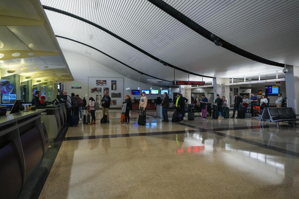 People wait in line for a rental car at the Des Moines International Airport on Monday, Nov. 14, 2022.