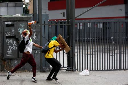 A demonstrator throws a petrol bomb while clashing with riot security forces during a strike called to protest against Venezuelan President Nicolas Maduro's government in Caracas, Venezuela, July 20, 2017. REUTERS/Carlos Garcia Rawlins