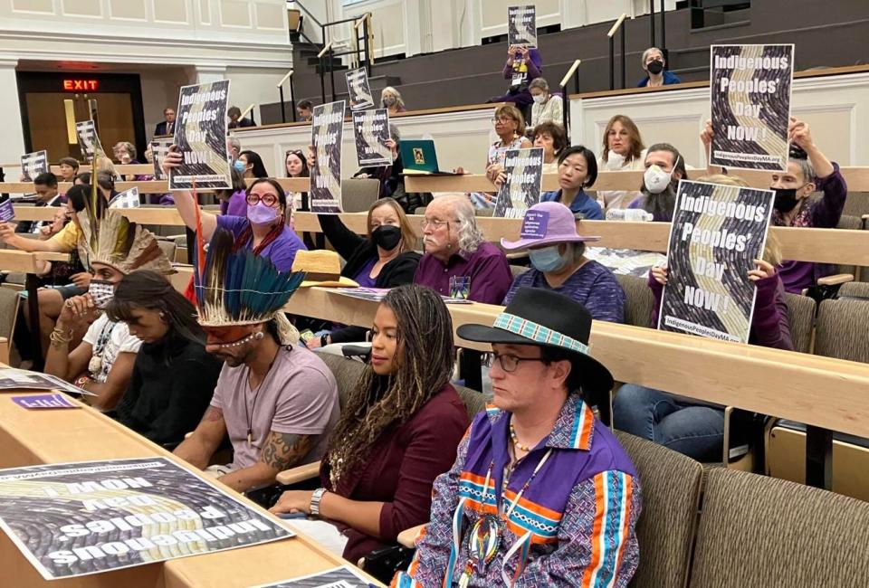 Supporters of legislation to establish Indigenous Peoples Day Massachusetts held up signs in Gardner Auditorium during a legislative hearing on Tuesday.