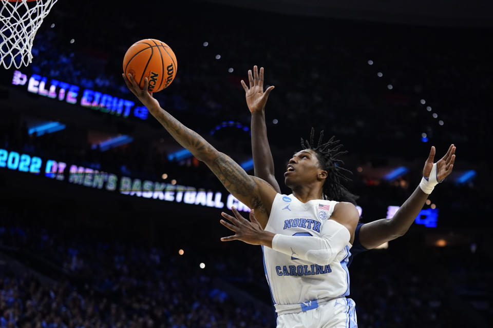 FILE - North Carolina's Caleb Love goes up for a shot past St. Peter's Clarence Rupert during the first half of a game in the NCAA men's college basketball tournament March 27, 2022, in Philadelphia. “We kind of want to write our own story,” Love said. “This is a new team. This is a new age. For us to go out this year and do what we've got to do, knowing what happened last year, we're more motivated than ever.” (AP Photo/Chris Szagola, File)