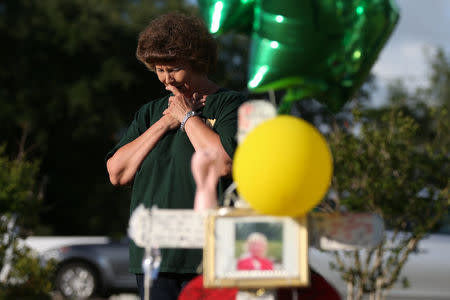 A woman mourns at a makeshift memorial left in memory of the victims killed in a shooting at Santa Fe High School in Santa Fe, Texas, U.S., May 23, 2018. REUTERS/Loren Elliott