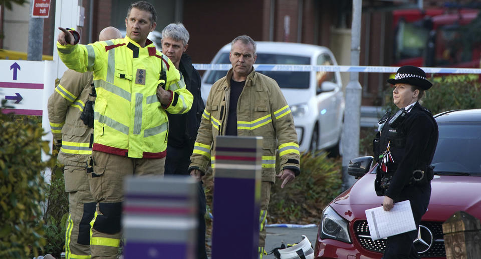 Fire fighters and police in discussion near the scene of the blast. Source: AP