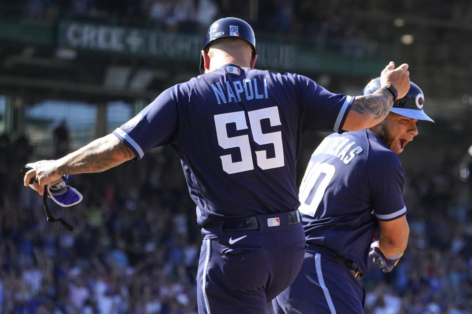 Chicago Cubs' Willson Contreras, right, celebrates with first base coach Mike Napoli, Contreras' two-run homer off Miami Marlins relief pitcher Dylan Floro during the eighth inning of a baseball game Friday, Aug. 5, 2022, in Chicago. The Cubs won 2-1. (AP Photo/Charles Rex Arbogast)