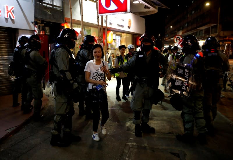 Riot police ask a woman to detour as they disperse pro-democracy demonstrators gathering to commemorate the three-month anniversary of an assault by more than 100 men on protesters, commuters and journalists, in Hong Kong