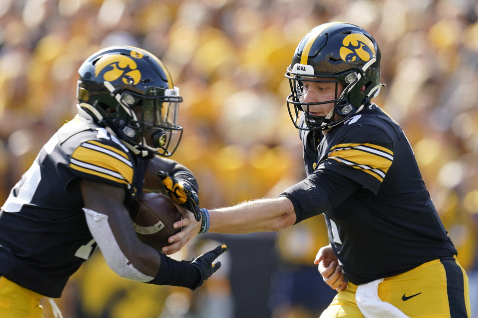 Iowa quarterback Spencer Petras hands the ball off to running back Tyler Goodson, left, during the first half of an NCAA college football game against Kent State, Saturday, Sept. 18, 2021, in Iowa City, Iowa. Iowa won 30-7. (AP Photo/Charlie Neibergall)