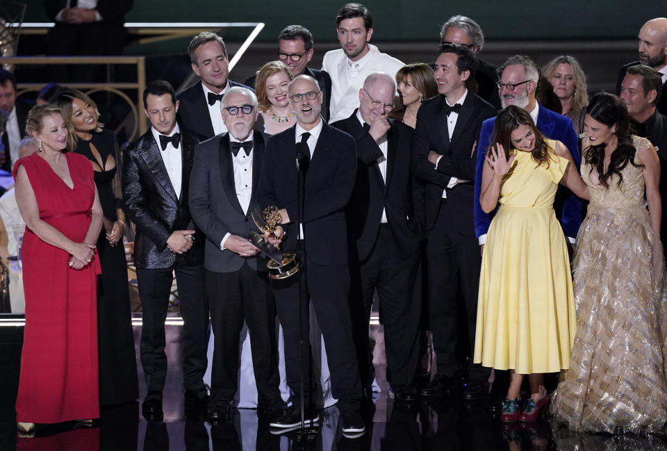 Jesse Armstrong, centro, y el elenco y equipo de producción de "Succession" reciben el Emmy a mejor serie de drama en la 74a entrega de los Premios Emmy el lunes 12 de septiembre de 2022 en el Teatro Microsoft en Los Angeles. (Foto AP/Mark Terrill)