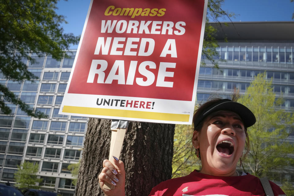 A worker contracted to feed World Bank employees through a firm called the Compass Group, protests for higher wages and affordable healthcare benefits, Wednesday, April 12, 2023, outside of the World Bank in Washington. (AP Photo/Mariam Zuhaib)